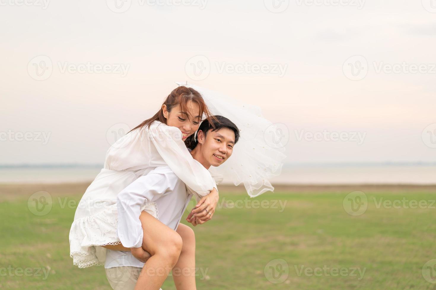 feliz jovem casal asiático em roupas de noivos foto