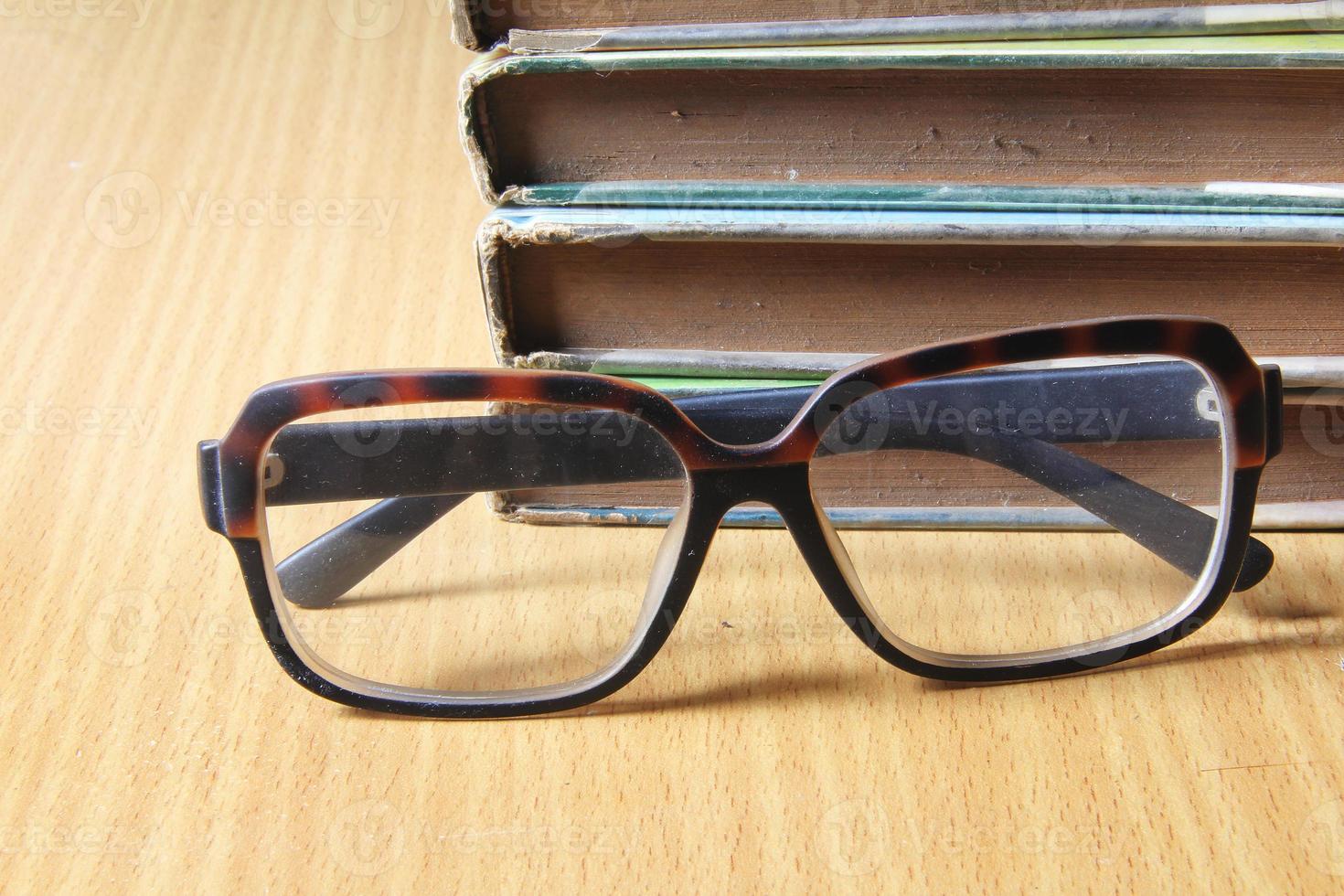 pilha de livros e óculos foto