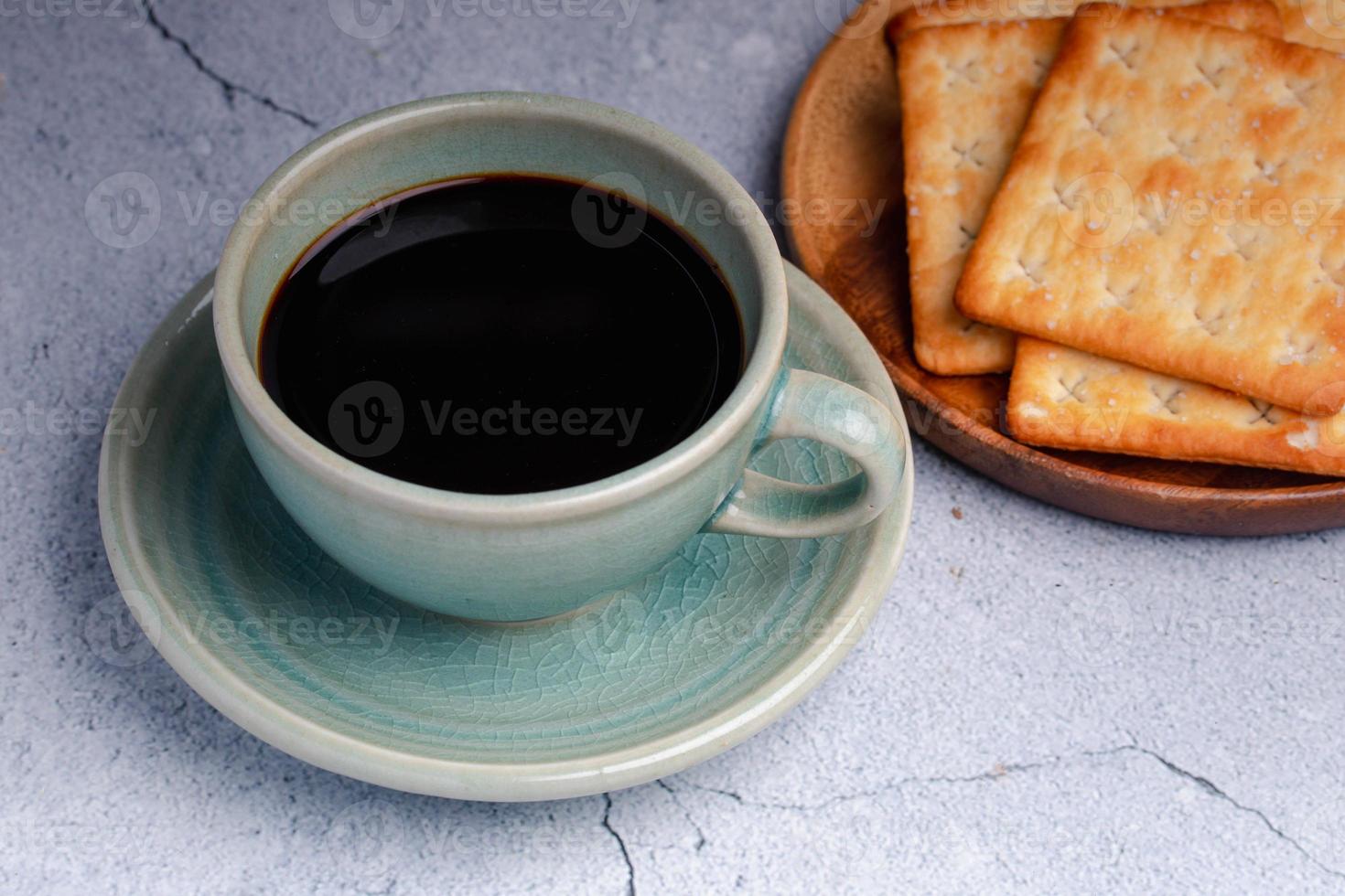 café preto quente em uma xícara de café verde com bolachas. foto