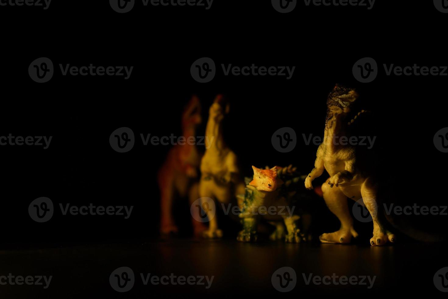 brinquedos de dinossauros em fundo preto foto