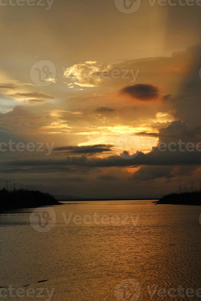 céu dramático colorido com nuvens ao pôr do sol. pôr do sol no lago foto