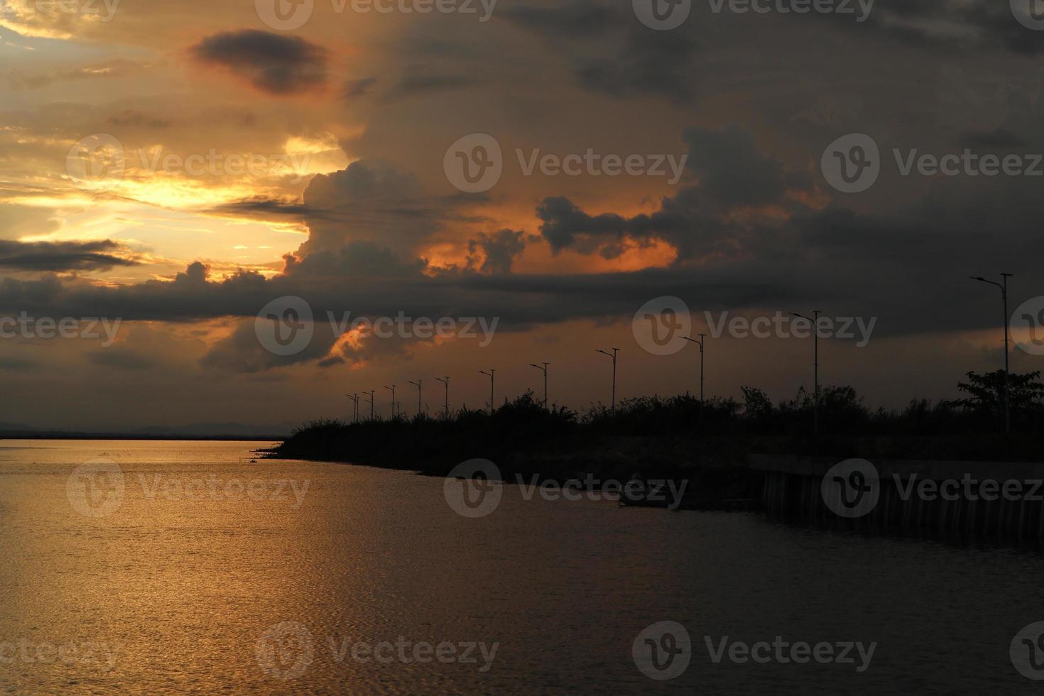 céu dramático colorido com nuvens ao pôr do sol. pôr do sol no lago foto