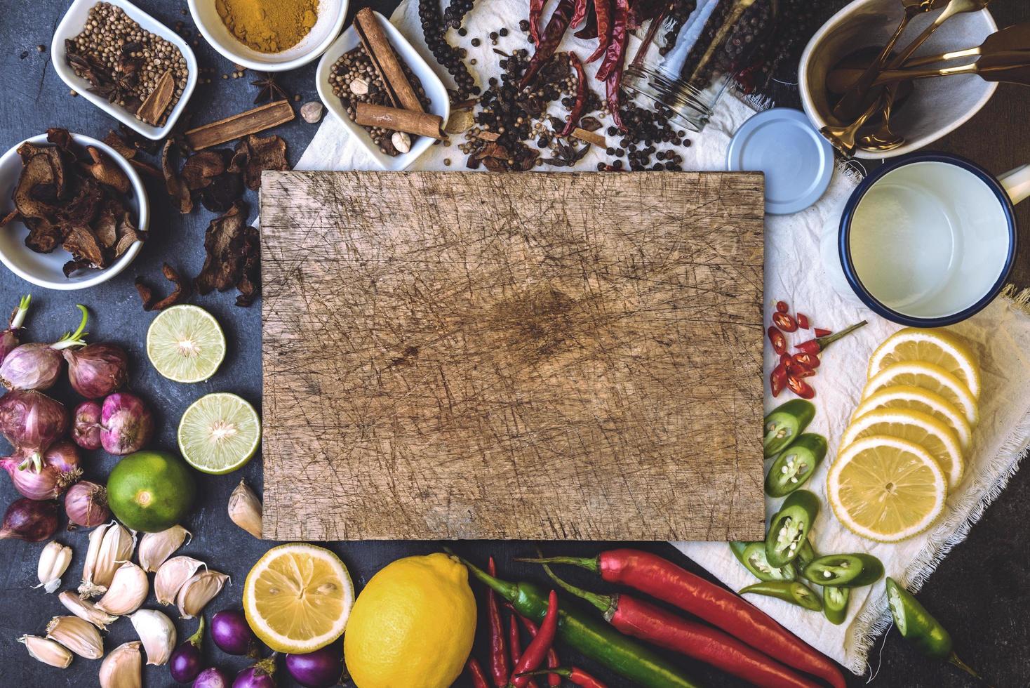alimentos saudáveis ervas especiarias para uso como ingredientes culinários em um fundo de madeira com vegetais orgânicos frescos na madeira. o conceito de ingredientes alimentares com variedade na mesa rústica. foto