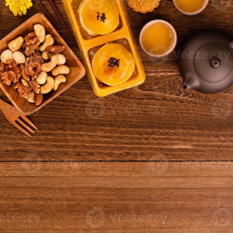 bolo de lua para o festival do meio do outono, delicioso bolo de lua fresco lindo em um prato sobre a mesa de fundo de madeira escura, vista superior, conceito de design de layout plano leigo. foto