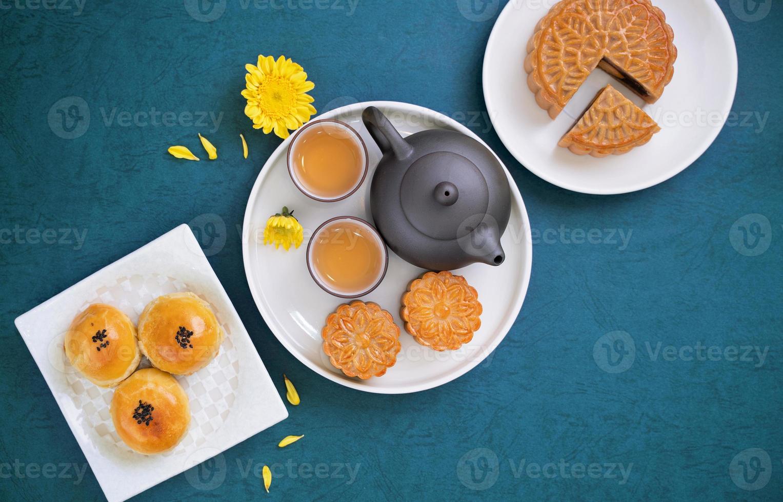 bolo de lua para o festival do meio do outono, delicioso bolo de lua fresco lindo em um prato sobre a mesa de fundo azul, vista superior, conceito de design de layout plano leigo. foto