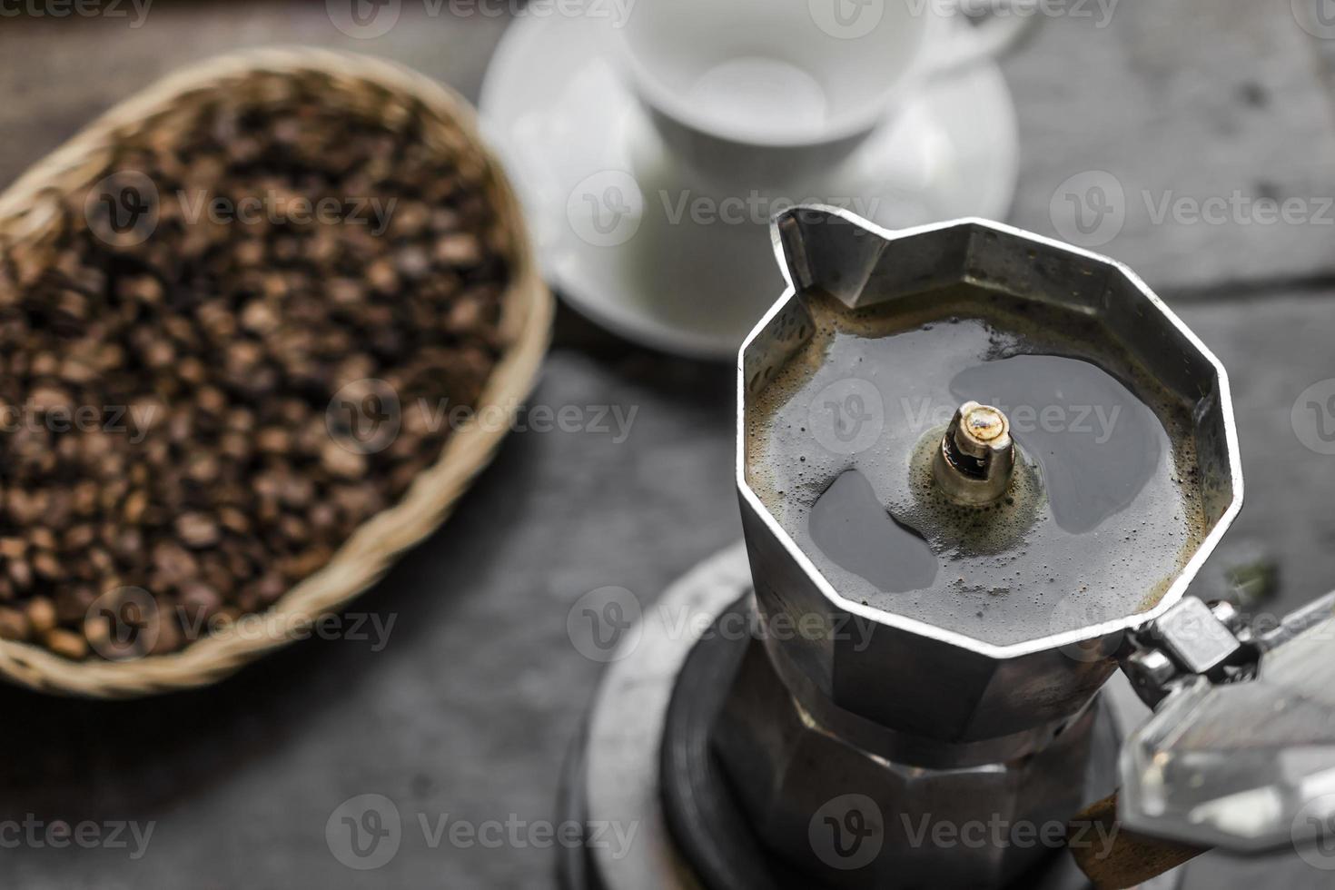 café expresso de manhã caseiro em pote de moka na mesa de madeira escura. foto