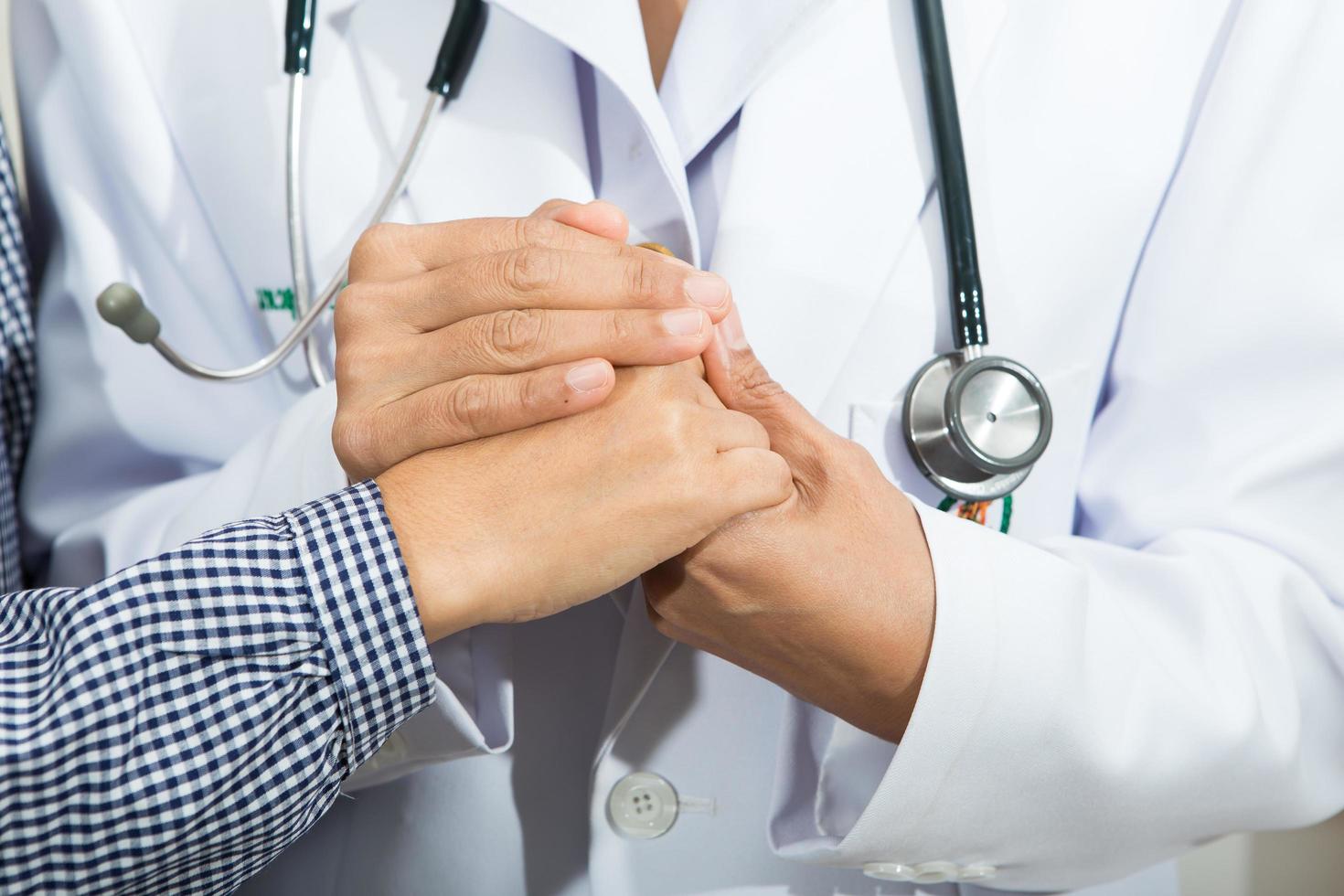 médico segurando as mãos do paciente sênior foto