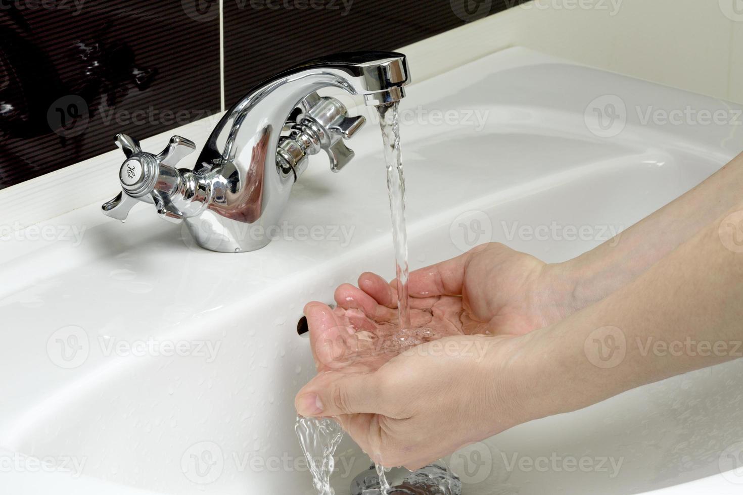 a pessoa lava as mãos em um banheiro foto