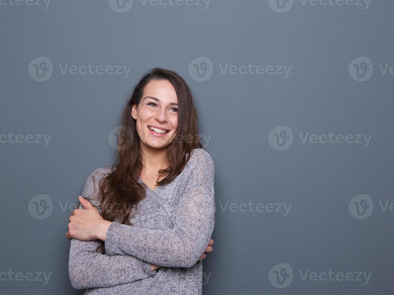 jovem mulher rindo com os braços cruzados foto