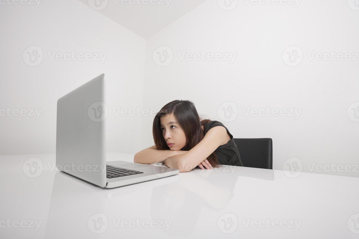 empresária jovem entediada olhando para laptop no escritório foto