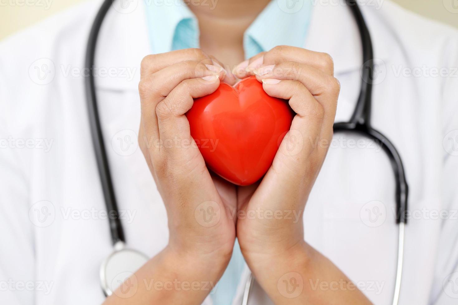 médica, mantendo uma forma bonita de coração vermelho foto