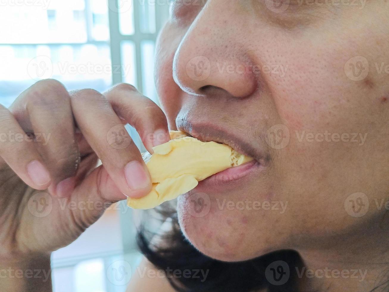 jovem mulher asiática come durian deliciosamente foto