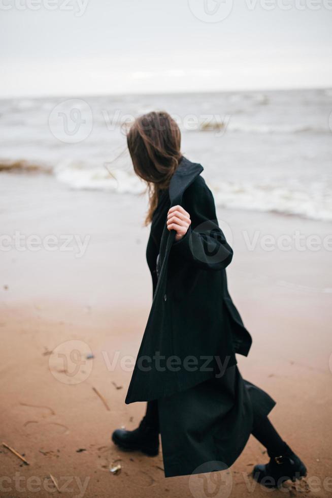 menina andando na praia do mar foto
