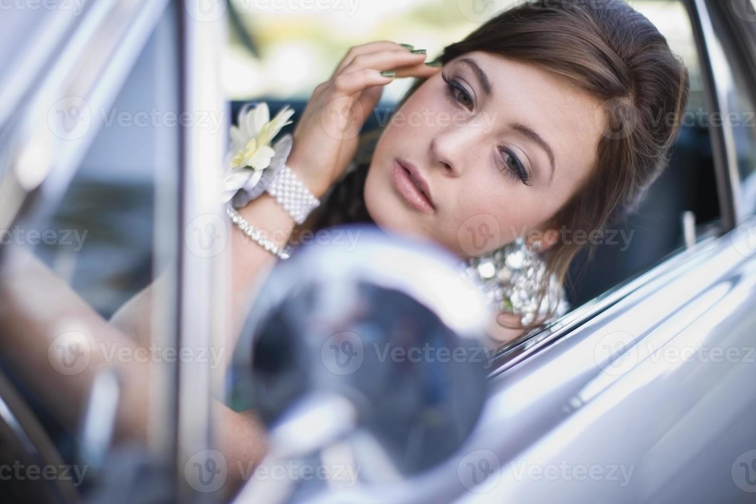adolescente, verificando a maquiagem no carro foto