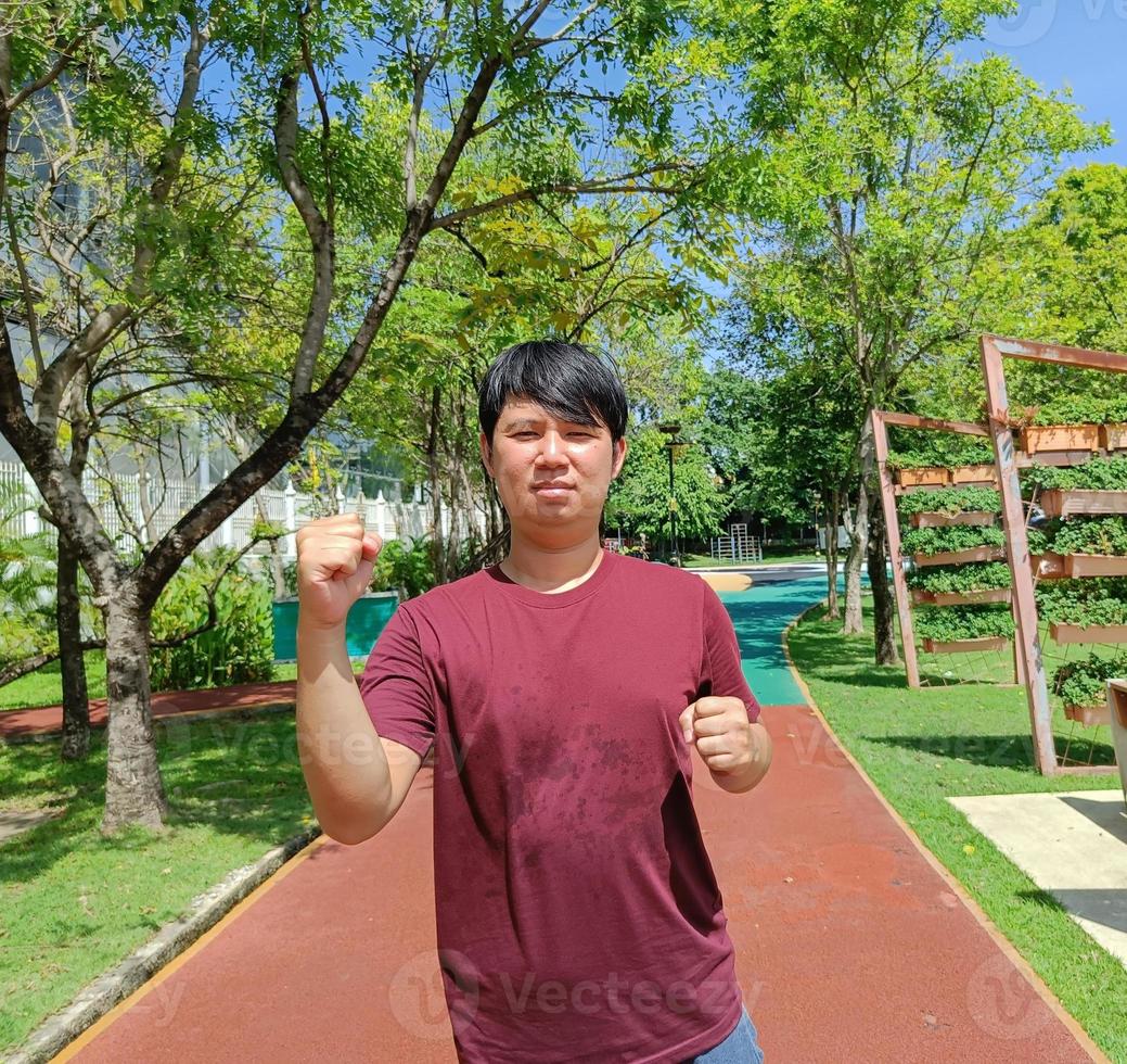 feliz jovem asiático corredor correndo no parque da cidade no verão foto