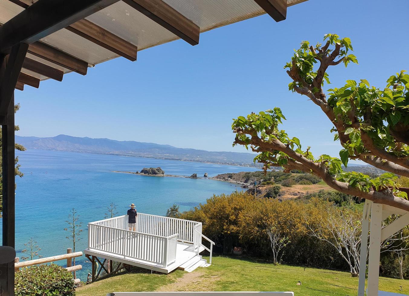 akamas, chipre - 22 de abril de 2022, um homem de chapéu está fotografando a vista panorâmica de uma bela baía na península de akamas, chipre foto