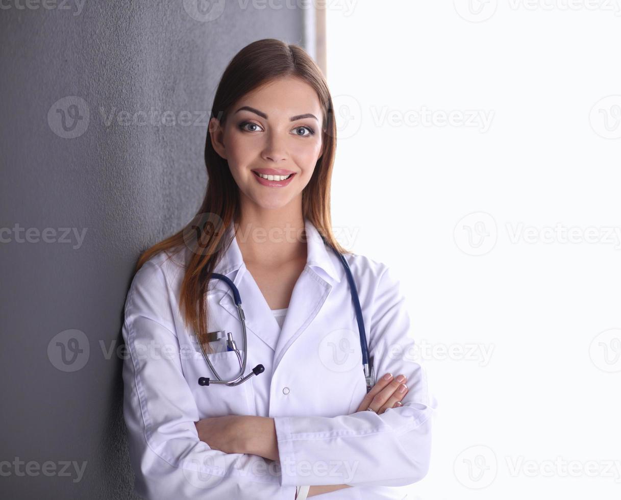 médico mulher com estetoscópio isolado em fundo cinza foto