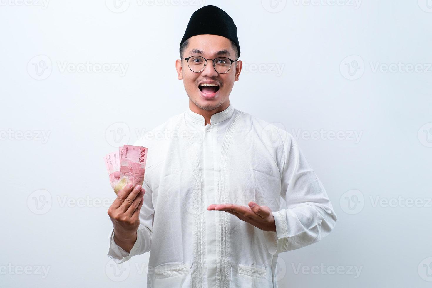 homem muçulmano asiático sorrindo feliz enquanto segura papel-moeda foto