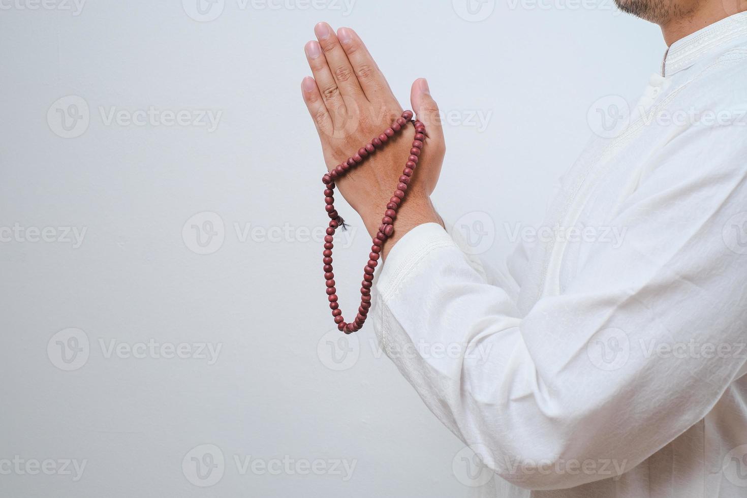 fechar a mão segurando um tasbih ou contas de oração foto