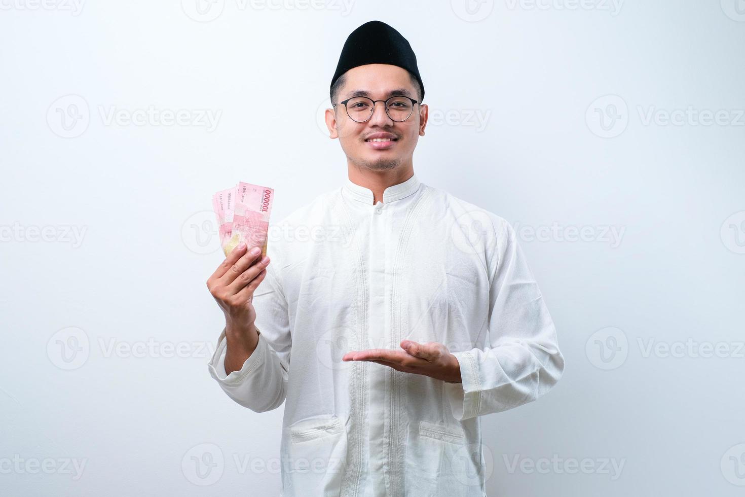 homem muçulmano asiático sorrindo feliz enquanto segura papel-moeda foto