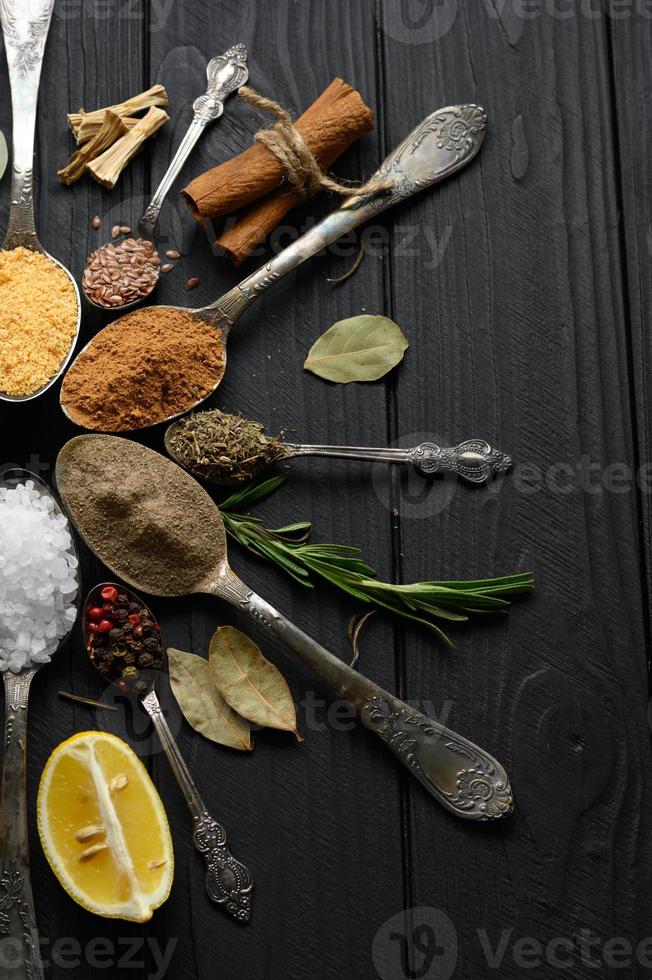 coloridas várias ervas e especiarias para cozinhar em fundo rústico de madeira escura foto