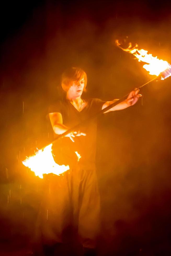 show de fogo no festival ao ar livre. artistas exalar chama, pilar de fogo em um fundo preto - 8 de julho de 2015, rússia, tver. foto