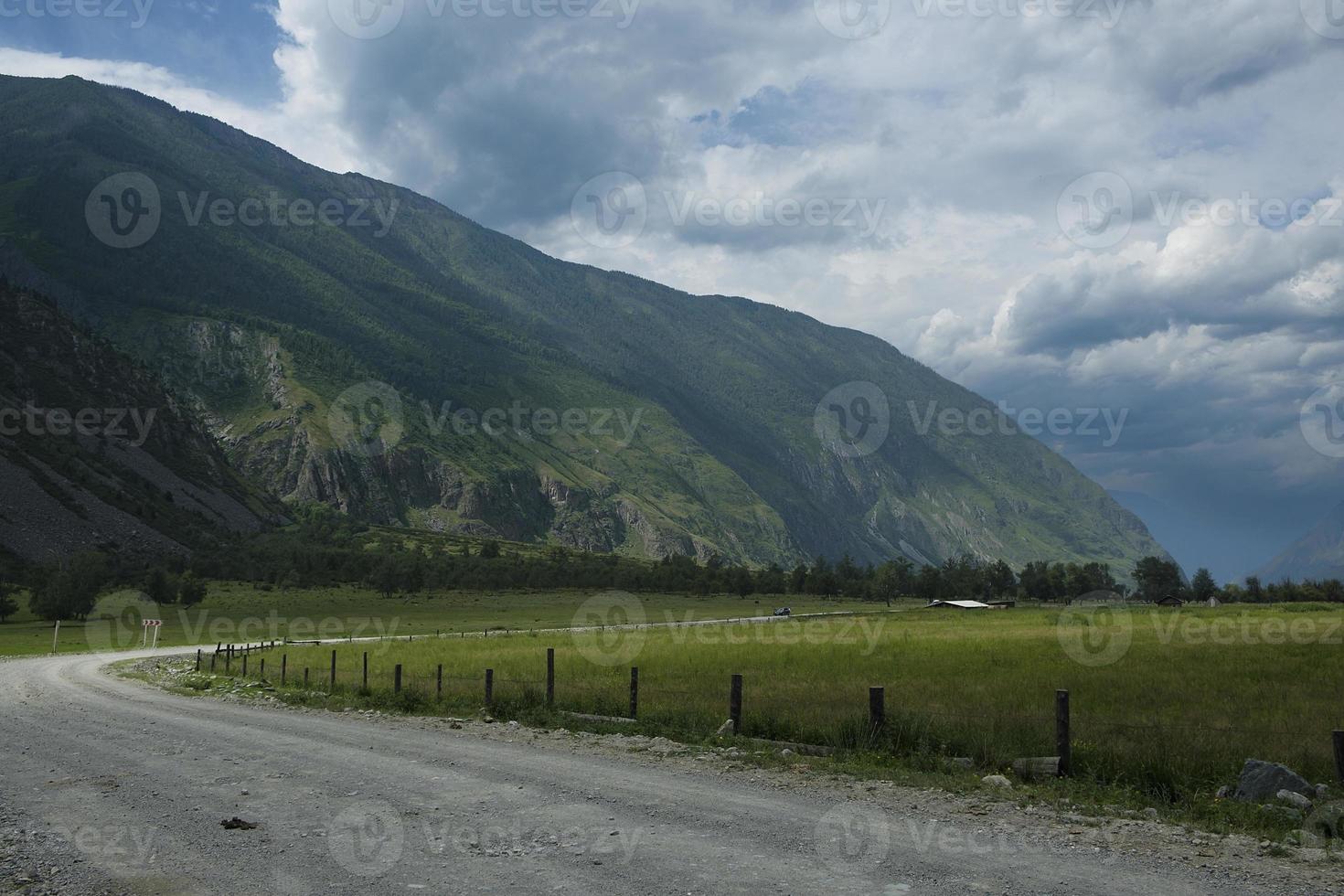 fita da estrada entre as encostas das montanhas nas extensões de altai em um dia de verão foto