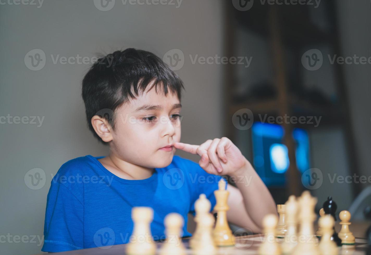 jovem concentrado desenvolvendo estratégia de xadrez, jogando jogo de tabuleiro com os pais em casa. atividade ou hobby para o conceito de família foto