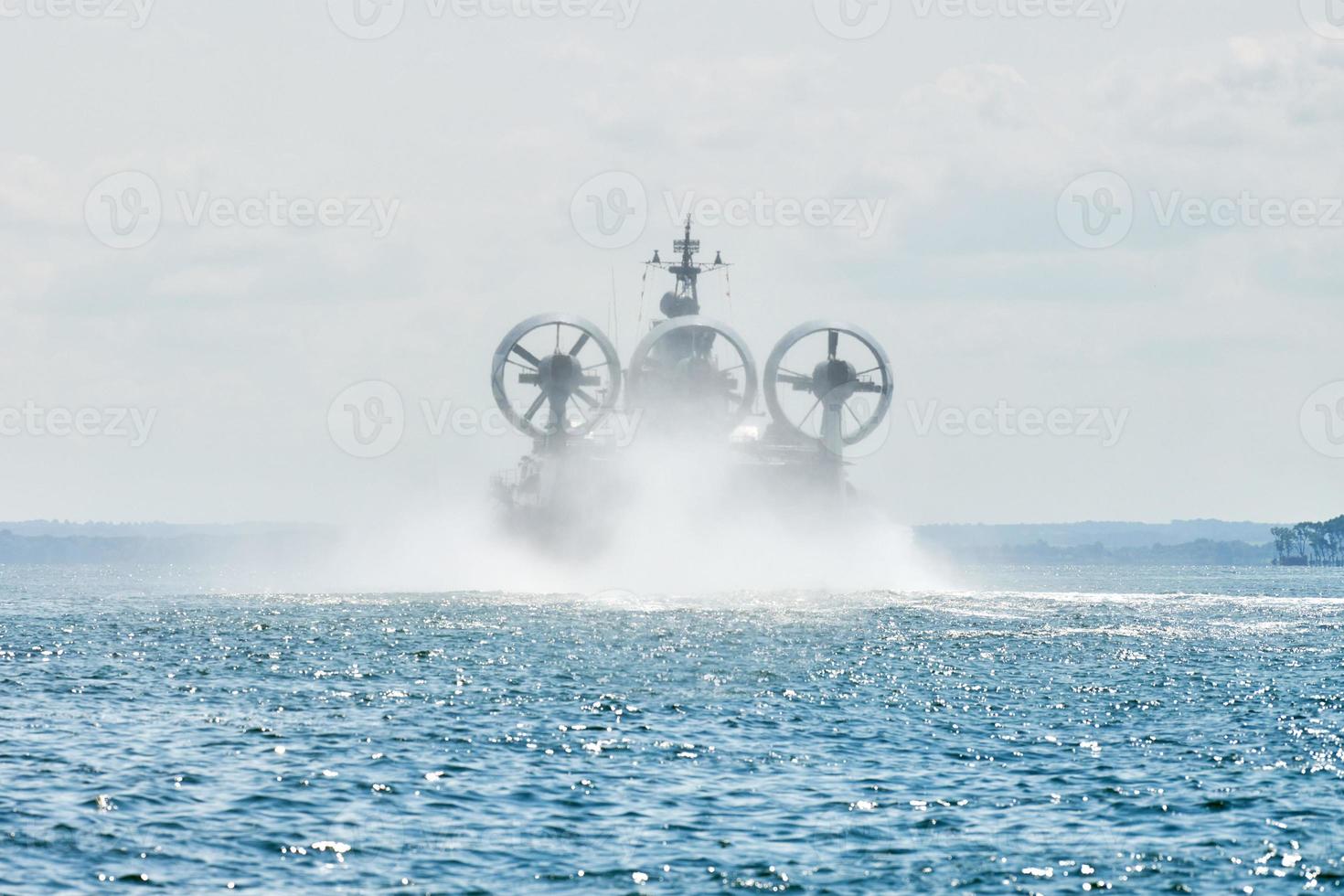 hovercraft de almofada de ar de desembarque voando acima da água, almofada de ar navegando espirrando água do mar foto