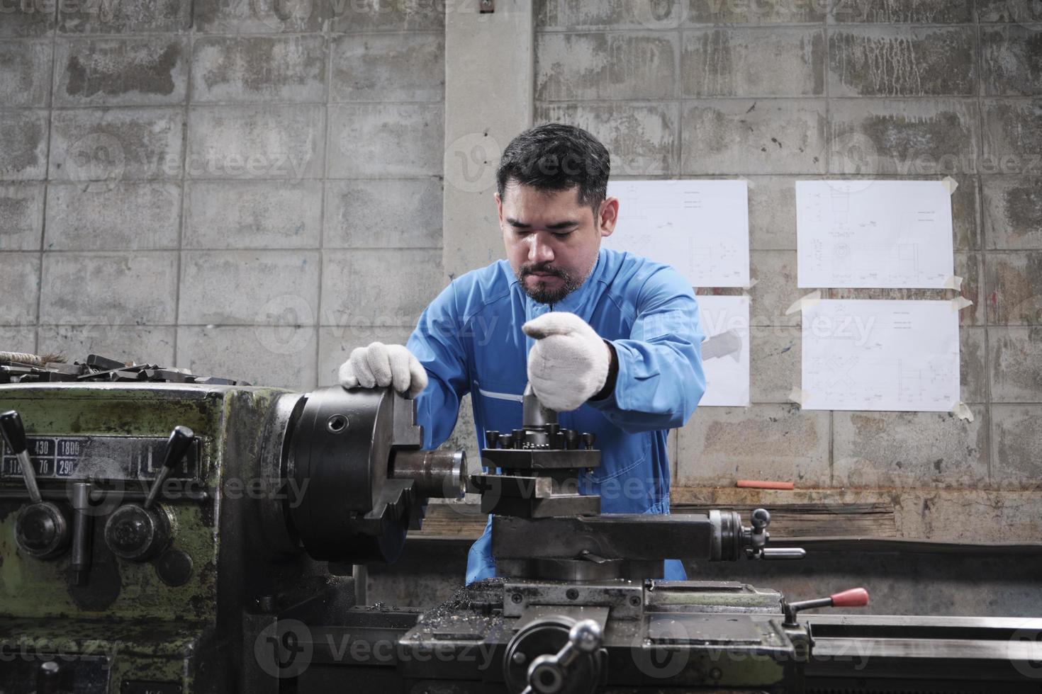 um trabalhador de engenheiro industrial masculino asiático profissional trabalha em um uniforme de segurança com ferramentas de precisão de metalurgia, tornos mecânicos e oficina de peças de reposição na fábrica de fabricação de aço. foto