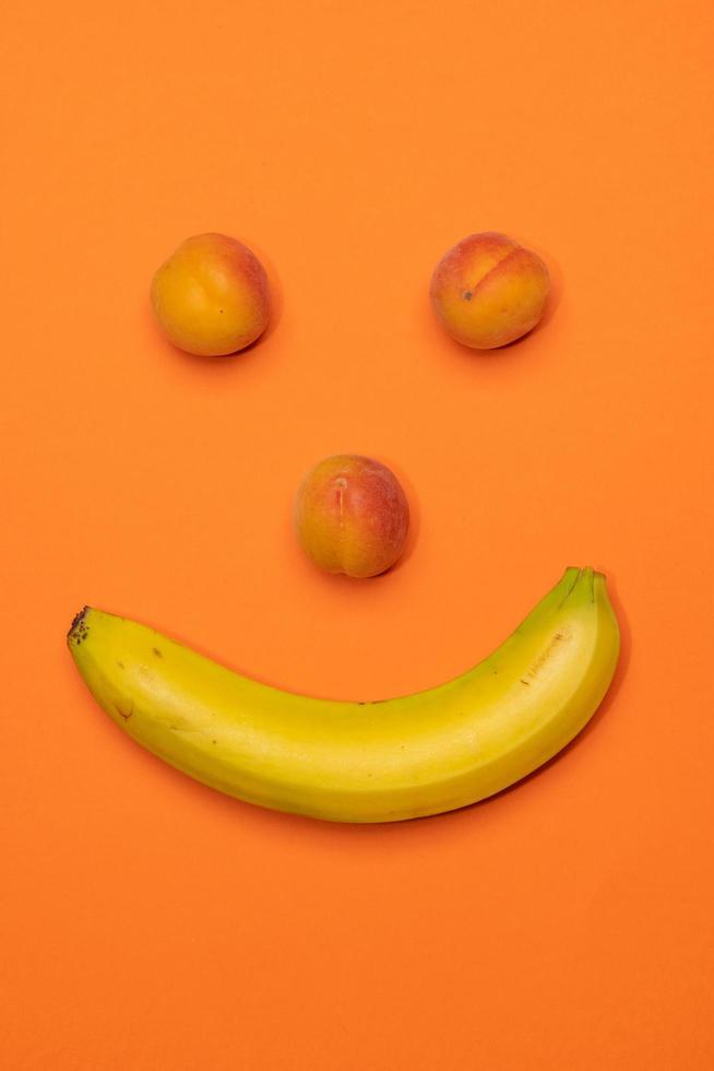 banana e pêssegos cara feliz ainda vida foto