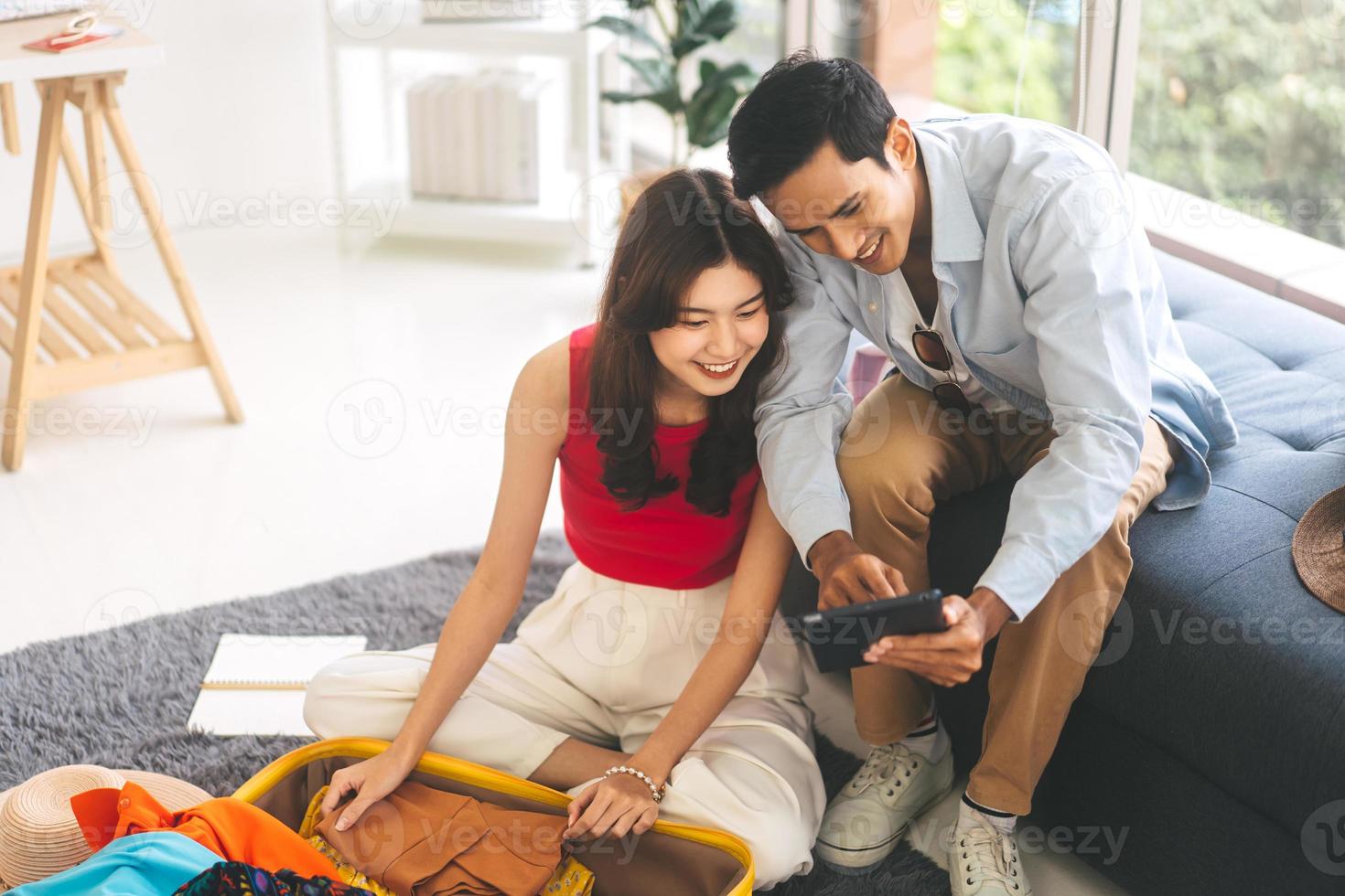 casal jovem adulto do sudeste asiático se preparando para viagem de férias juntos em casa foto