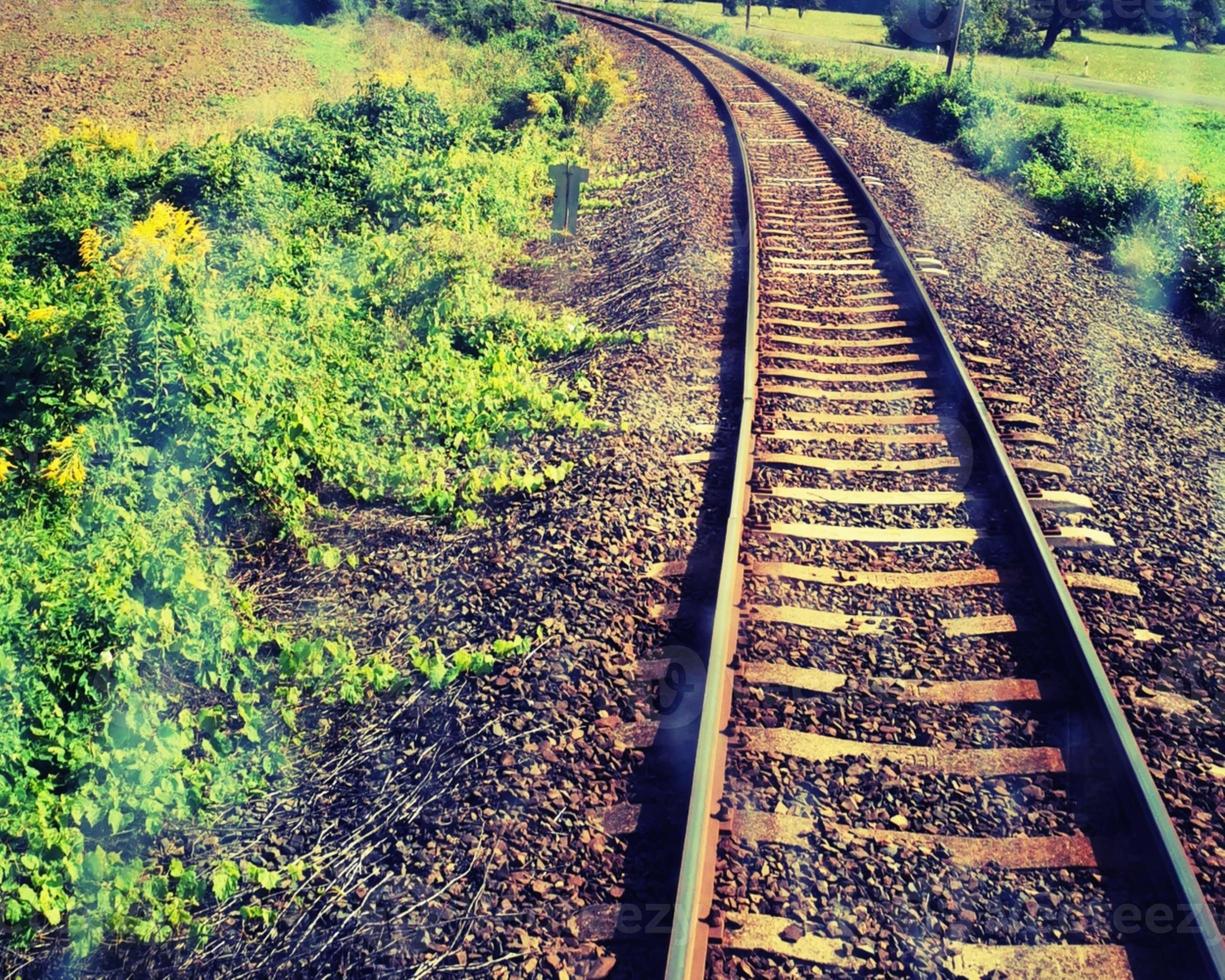 skyline de trilho de trem e campo verde fotografado do trem foto