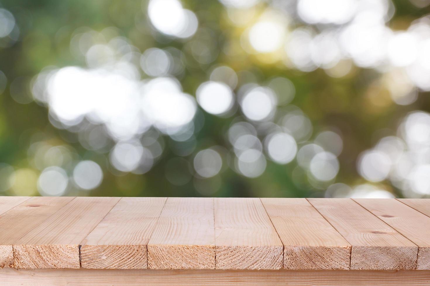 tampo de mesa de madeira marrom sobre fundo verde abstrato bokeh - pode ser usado para montagem ou exibir seus produtos foto