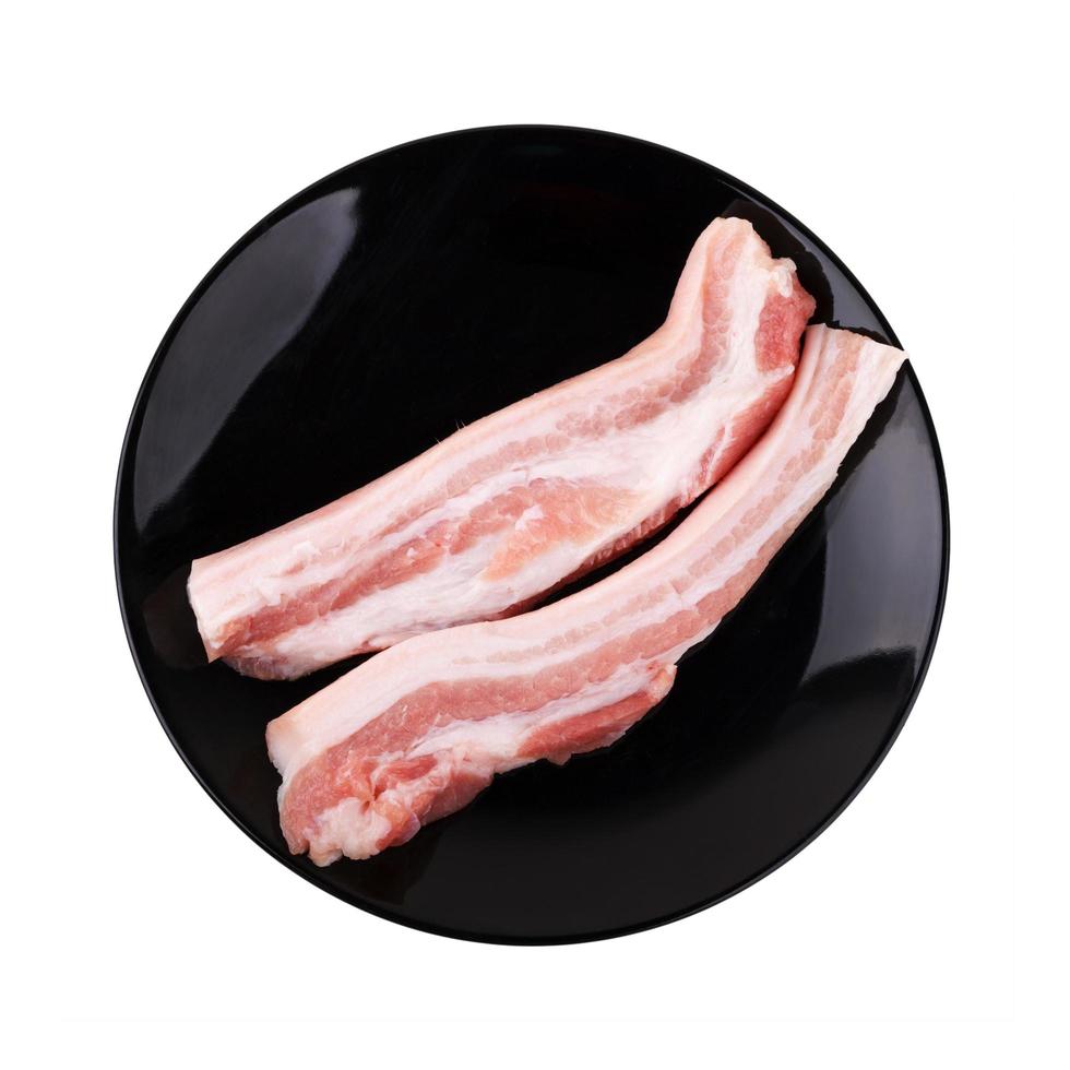 carne de porco entremeada no prato no fundo branco foto