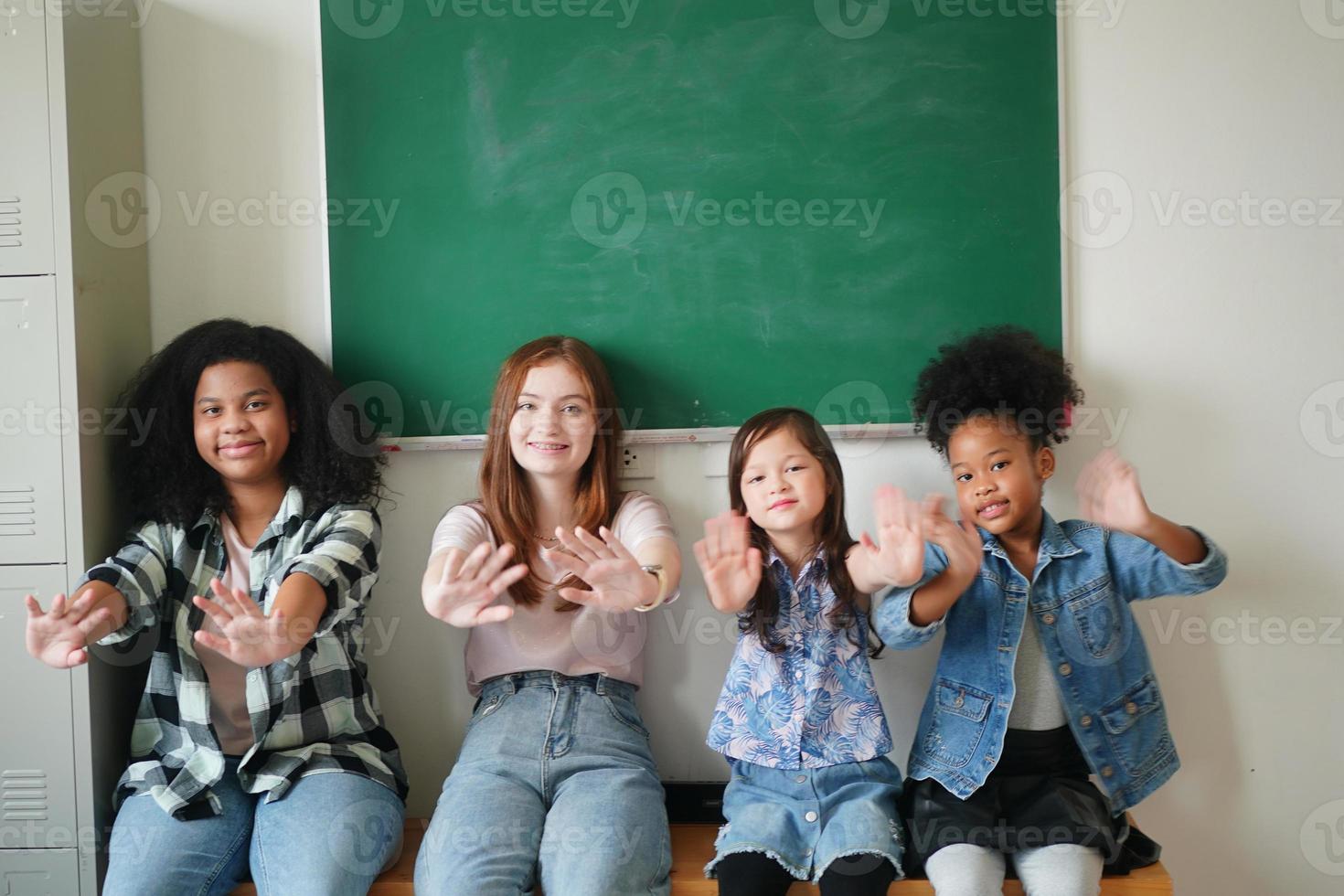 meninas felizes contra a lousa com volta às aulas foto