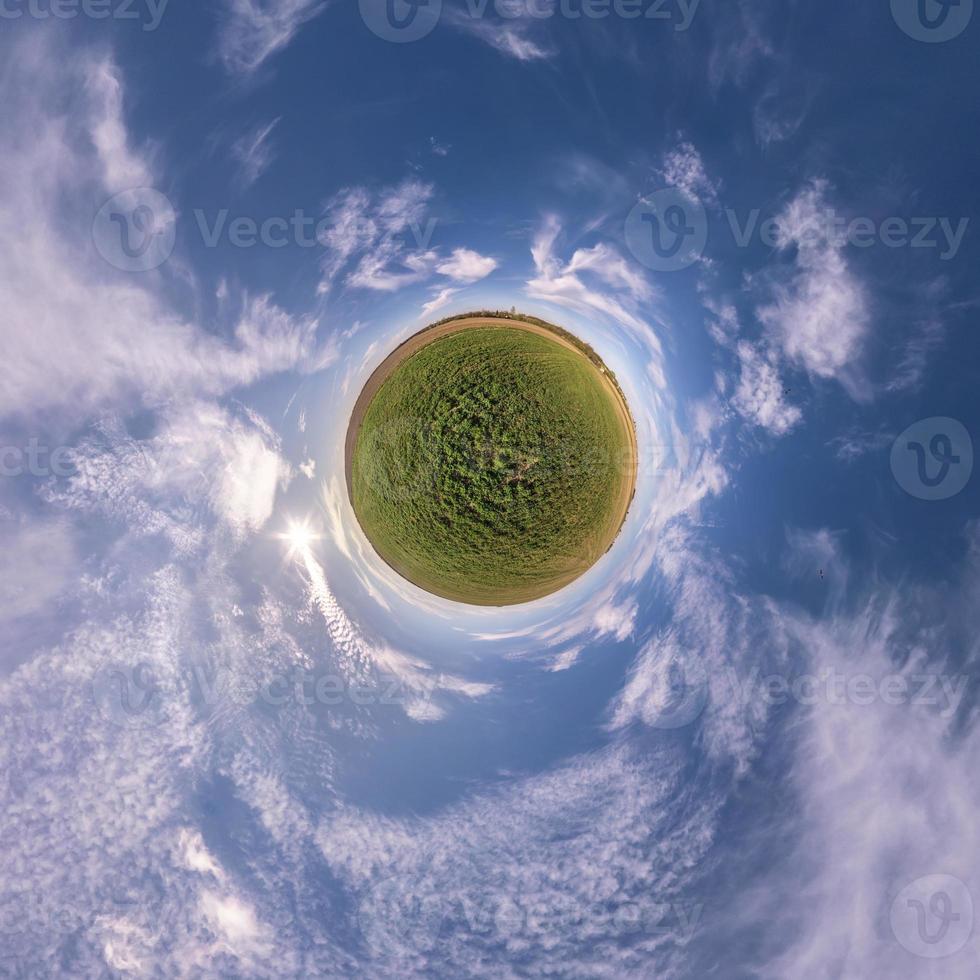 pequeno planeta no céu azul com sol e belas nuvens. transformação do panorama esférico 360 graus. vista aérea abstrata esférica. curvatura do espaço. foto