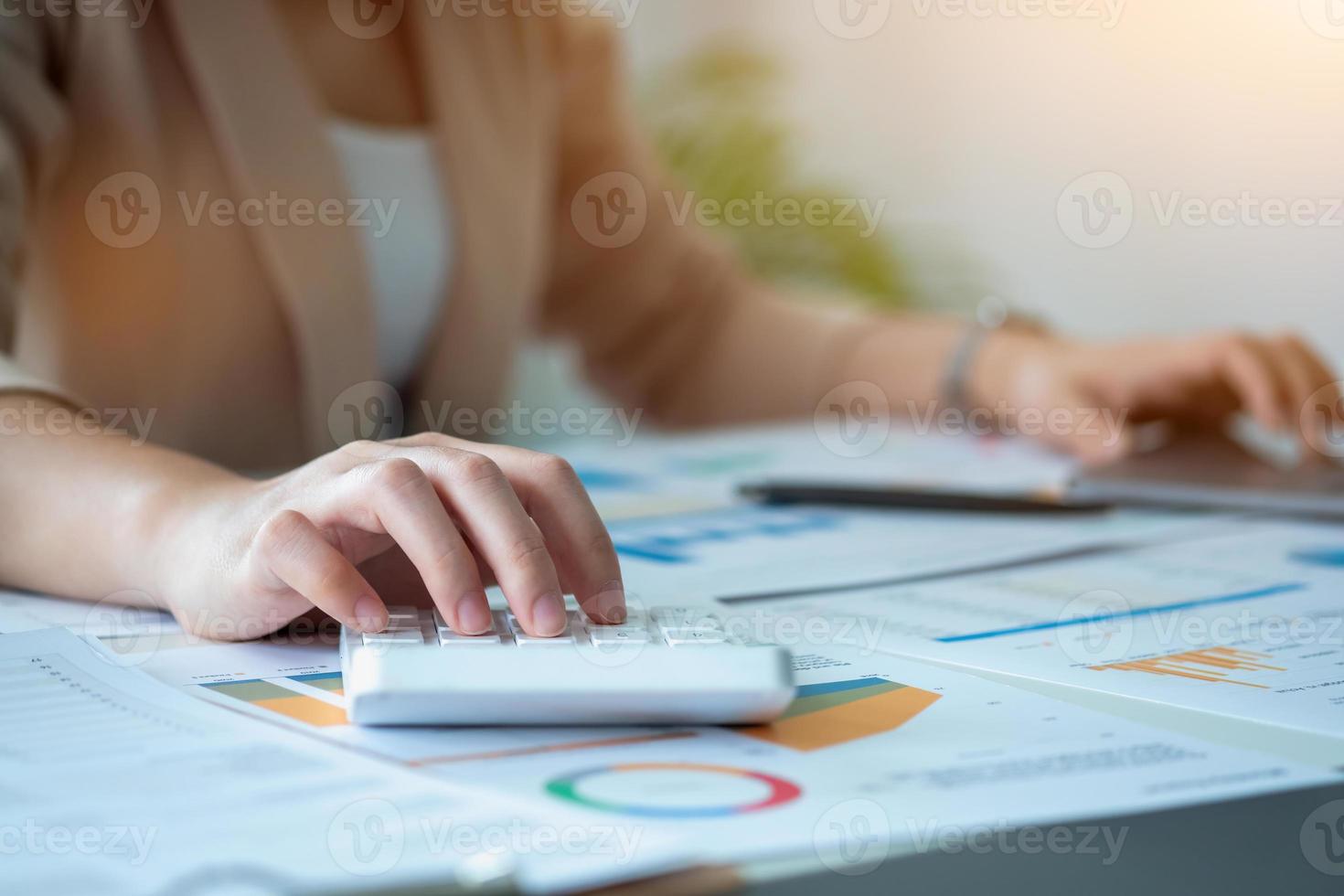 marketing, financeiro, contabilidade, planejamento, equipe de empresárias e economistas usam calculadoras e computadores e documentos gráficos para lucrar com a empresa. foto