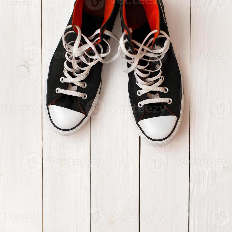 sapatos pretos elegantes e elegantes em um fundo branco de madeira foto