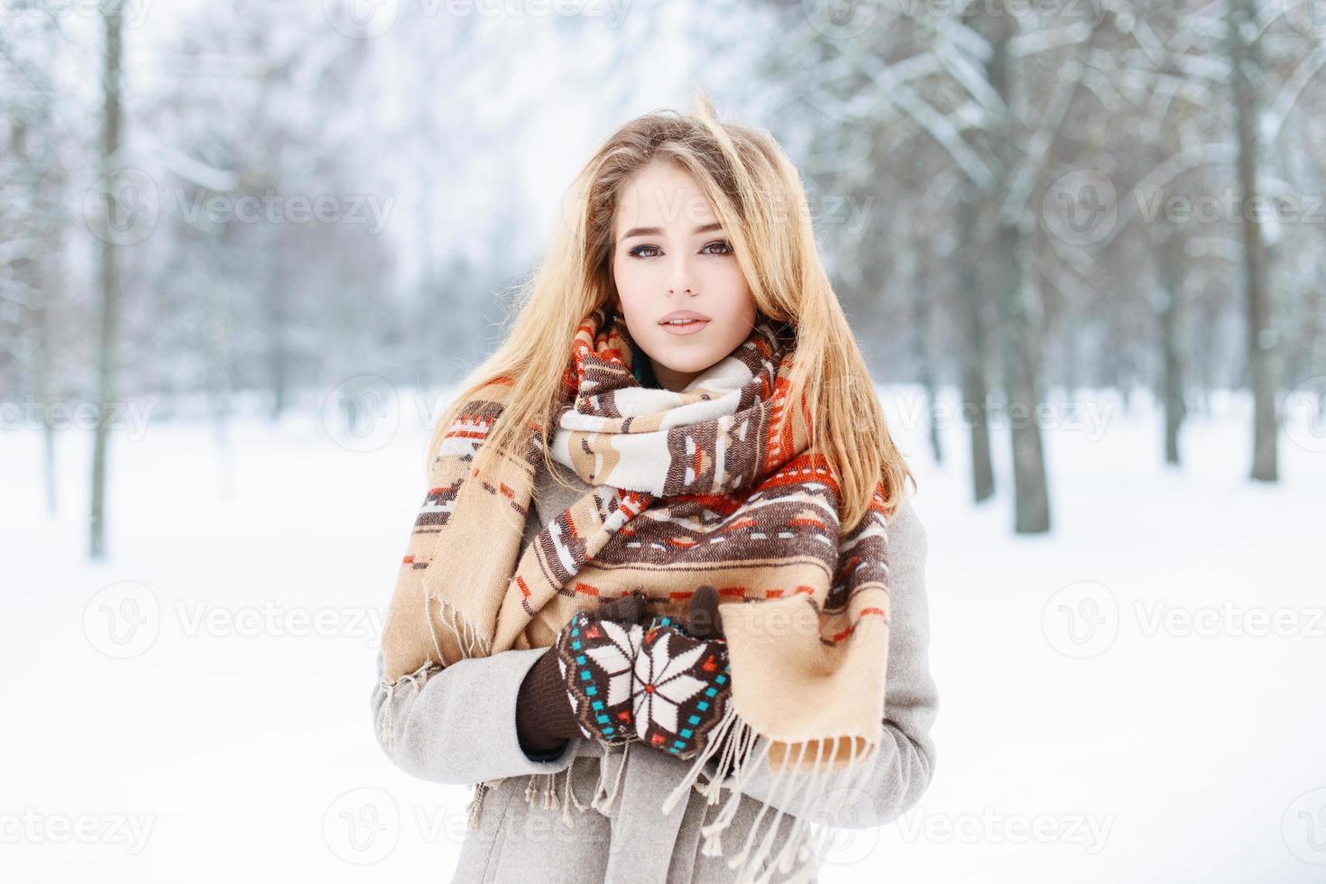 retrato de inverno de uma bela jovem com cachecol perto do parque nevado foto