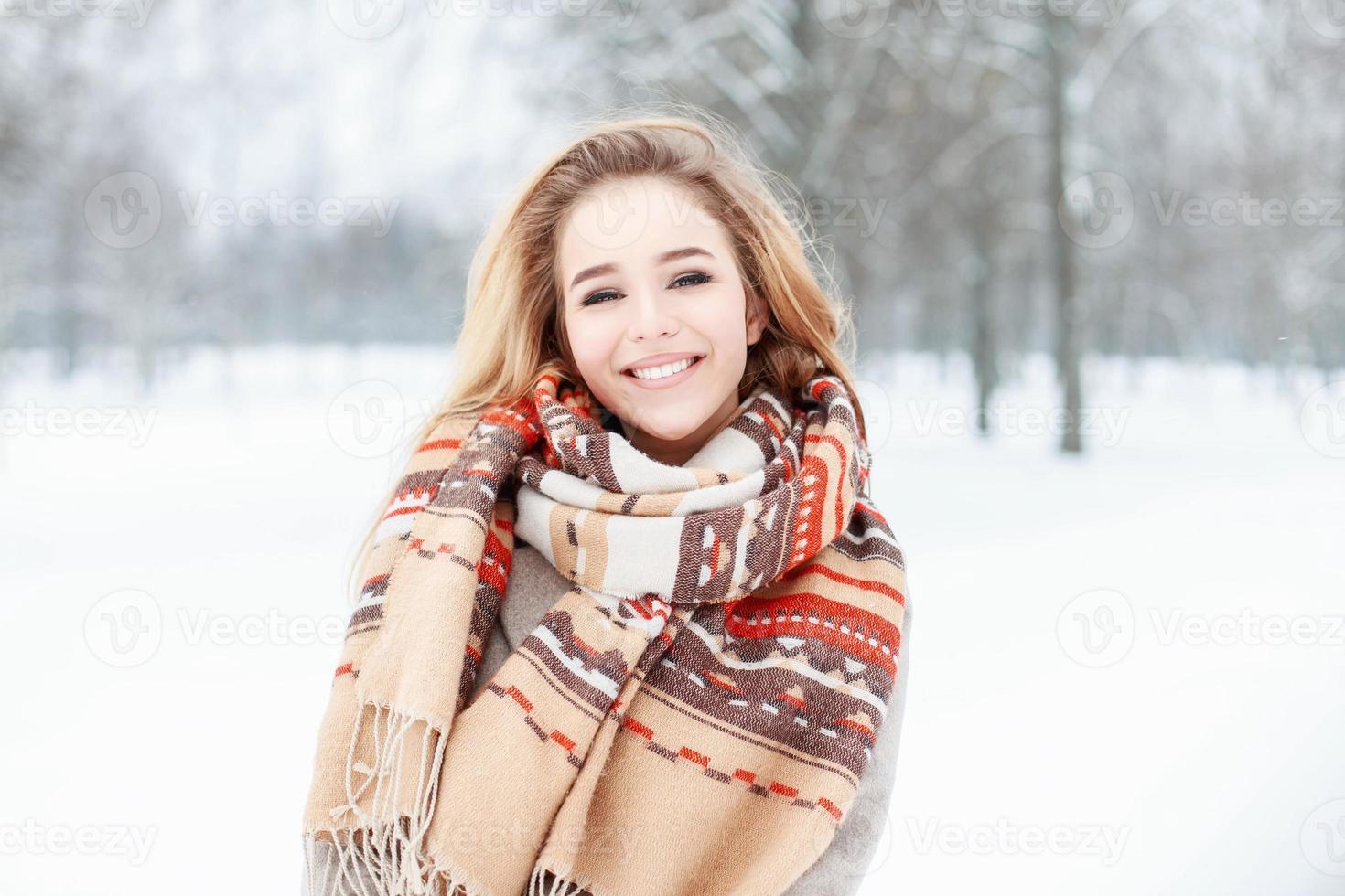 menina bonita com um sorriso fofo no cachecol vintage e luvas em dia de inverno foto