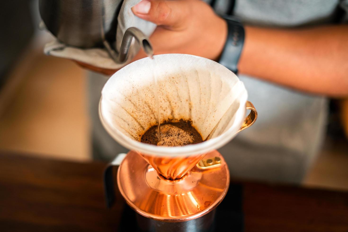 café por gotejamento, barista derramando água no café moído com filtro foto