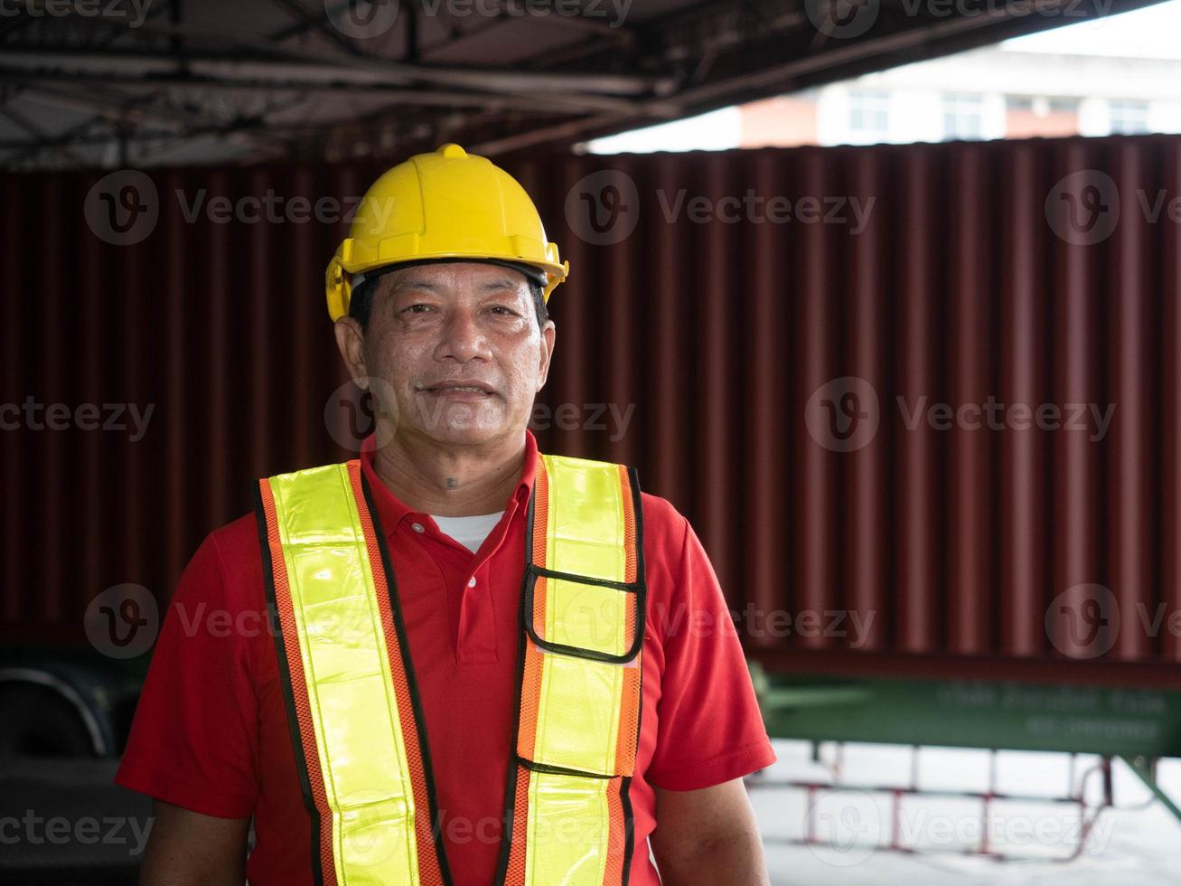 masculino gordo idoso gerente de equipe sênior capacete capacete de segurança amarelo segurança está de pé olhe para a câmera trabalho trabalho carreira profissional bem sucedido recipiente de entrega de carga logística importação exportação indústria foto