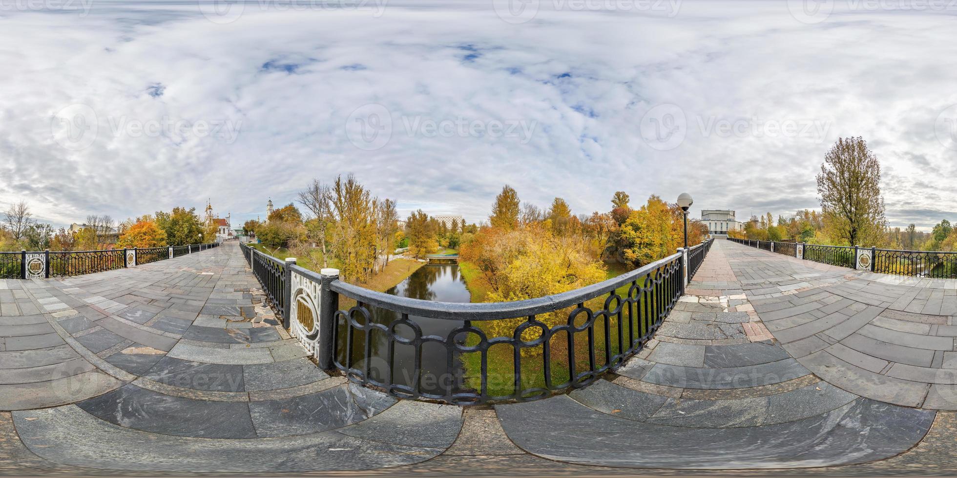 panorama completo do cubo esférico sem costura visão de ângulo de 360 graus na ponte pedonal através do pequeno rio no parque da cidade de outono em projeção equirretangular, pronto para conteúdo de realidade virtual ar vr foto