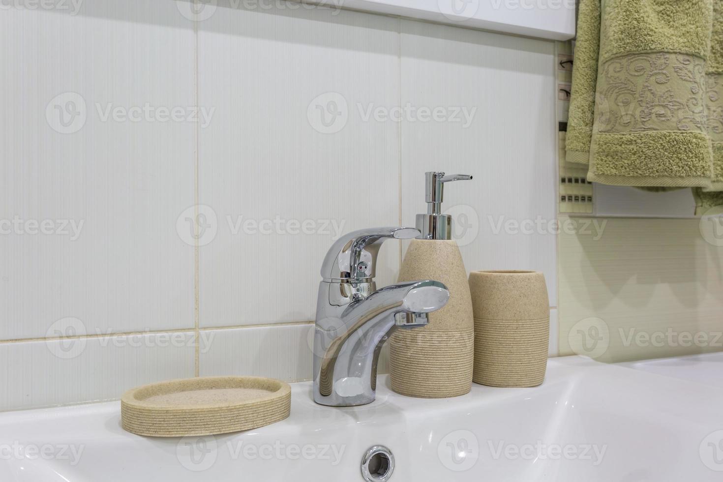dispensadores de sabonete e xampu perto da pia de cerâmica com torneira no banheiro ou cozinha do loft caro foto