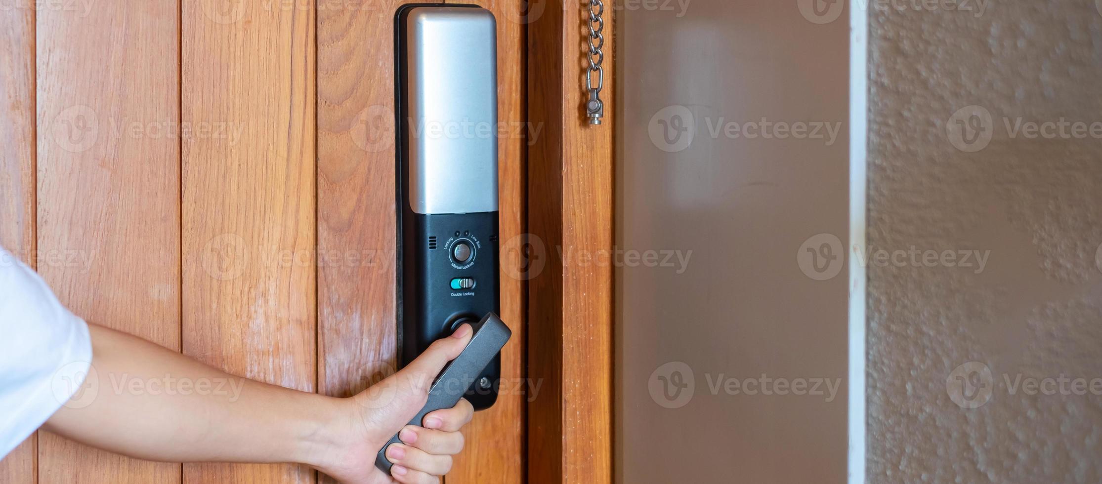 homem segurando a maçaneta da fechadura digital inteligente enquanto abre ou fecha a porta. conceitos de tecnologia, elétrica e estilo de vida foto