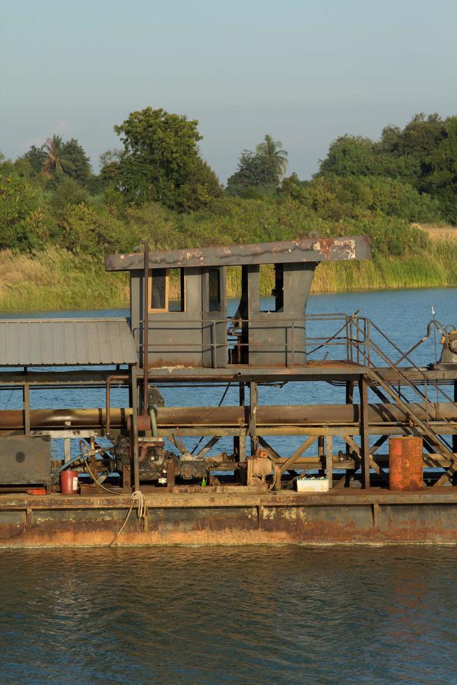 as embarcações de sucção de areia estão transportando areia de tubos de aço em rios profundos para a construção de indústrias como casas, prédios, estradas e muitas outras onde a areia é usada como mistura. foto