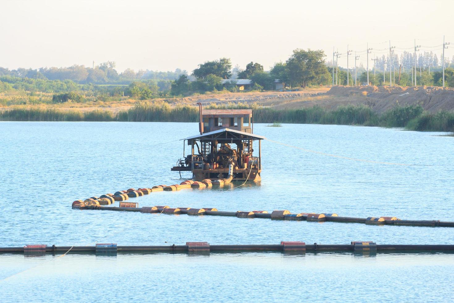 as embarcações de sucção de areia estão transportando areia de tubos de aço em rios profundos para a construção de indústrias como casas, prédios, estradas e muitas outras onde a areia é usada como mistura. foto