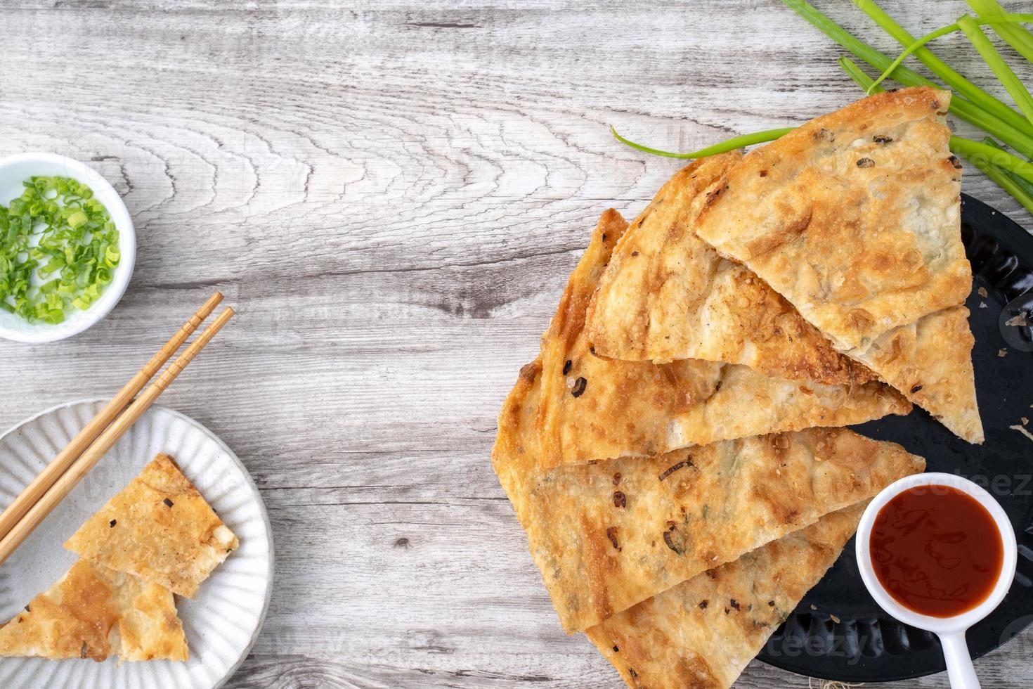 panqueca de cebolinha deliciosa taiwanesa sobre fundo de mesa de madeira foto