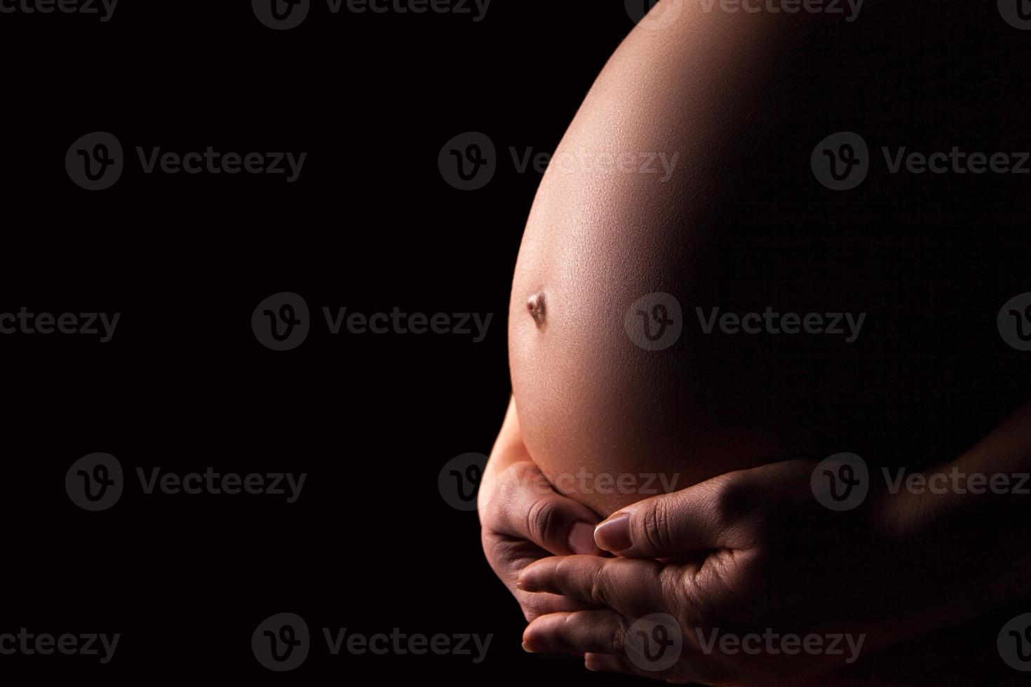 silhueta de mulher grávida sobre fundo preto foto